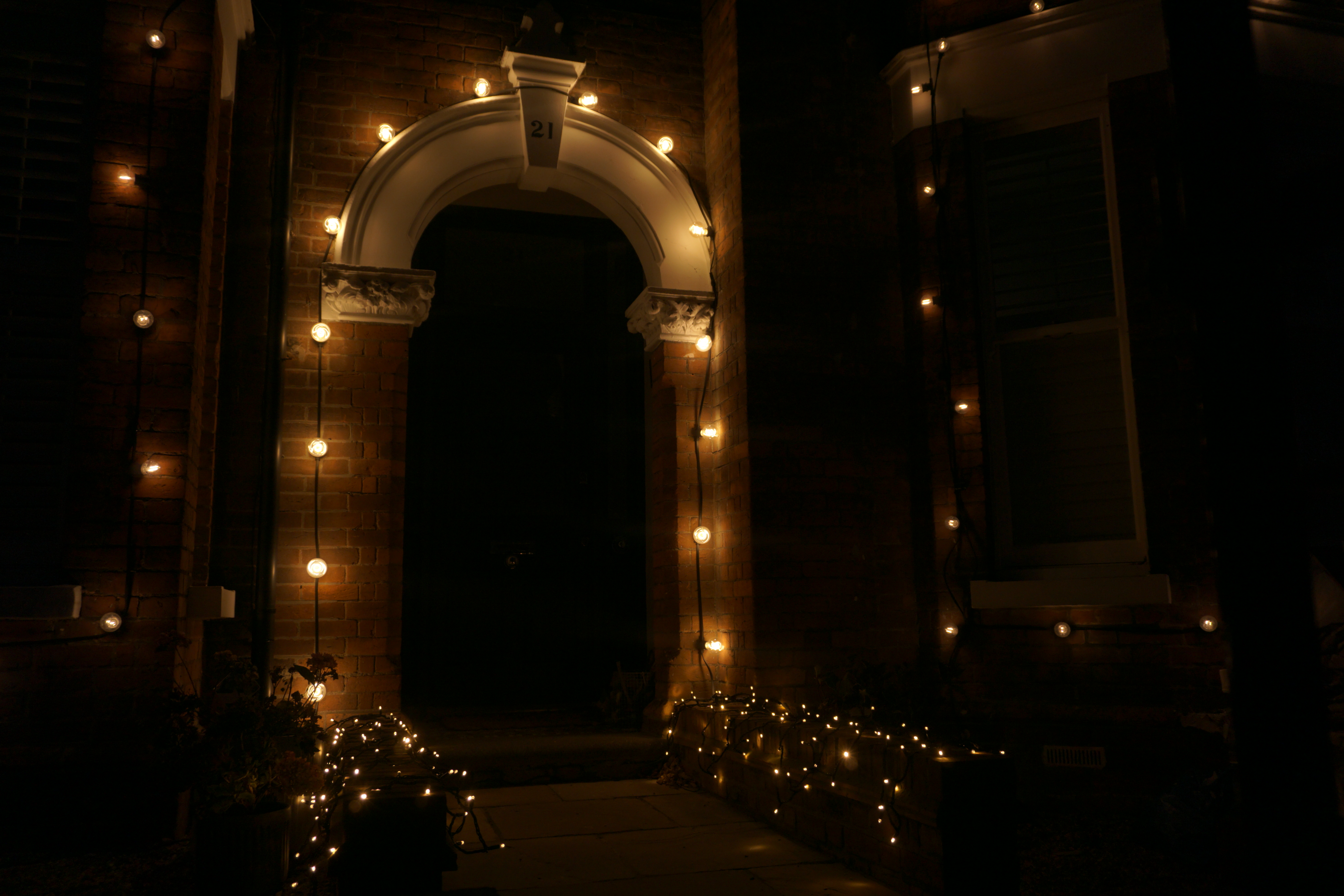 Festoon lighting around a brick entrance archway