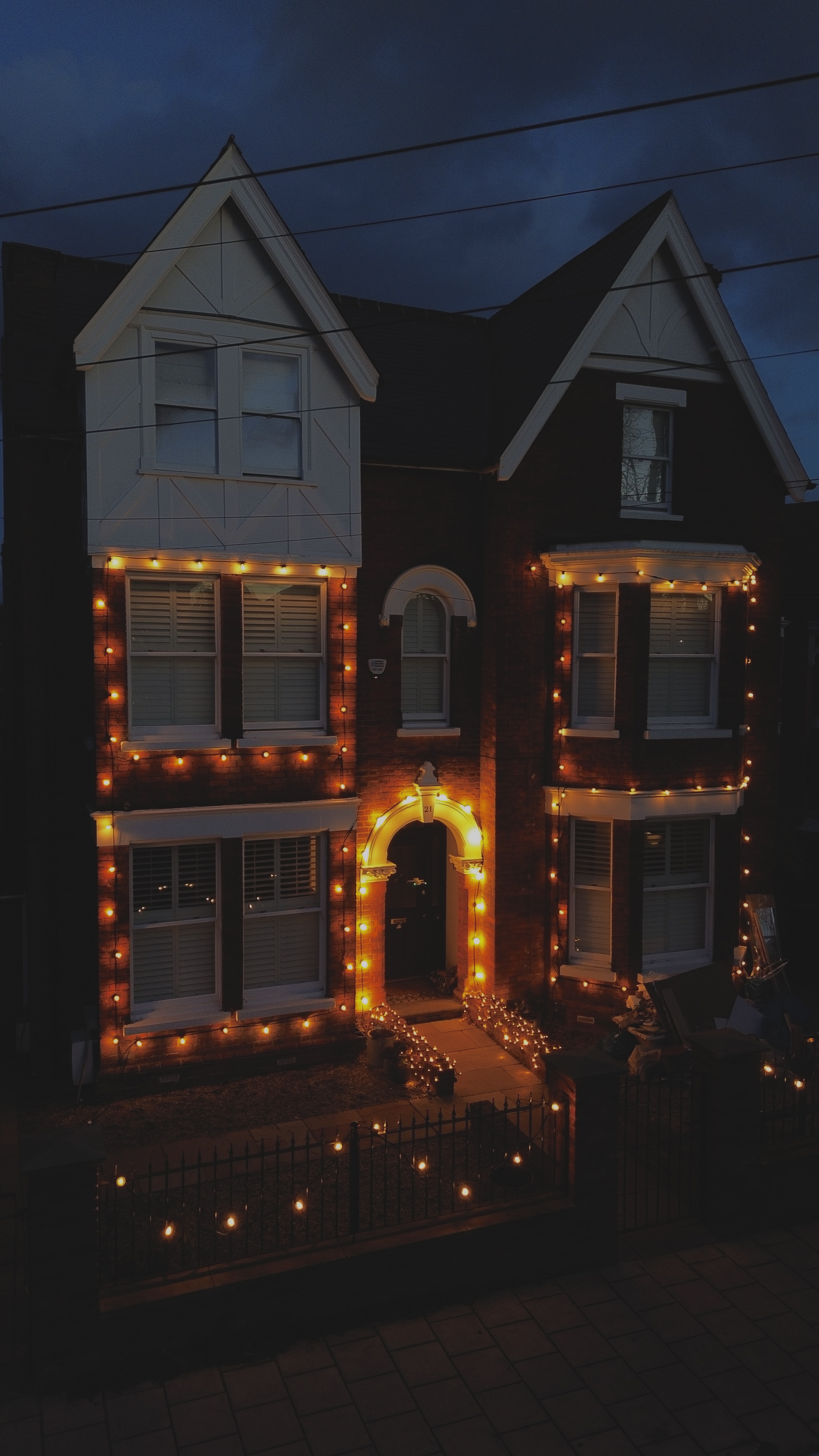 House Christmas lighting at dusk with blue sky
