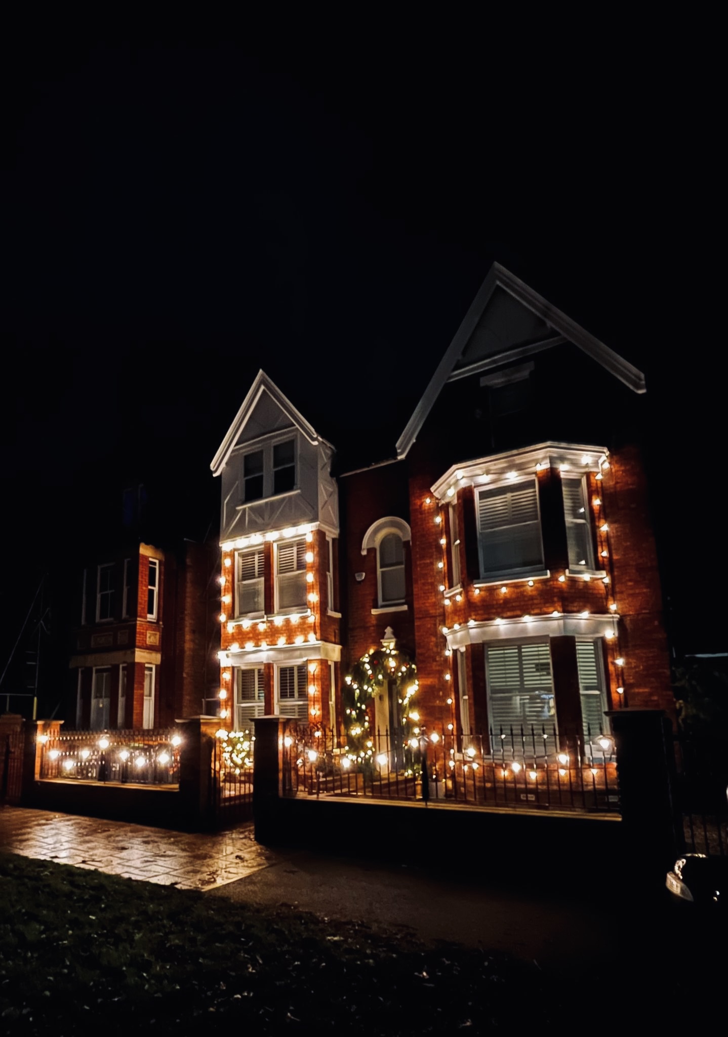 Detached house fully outlined in Christmas lights at night