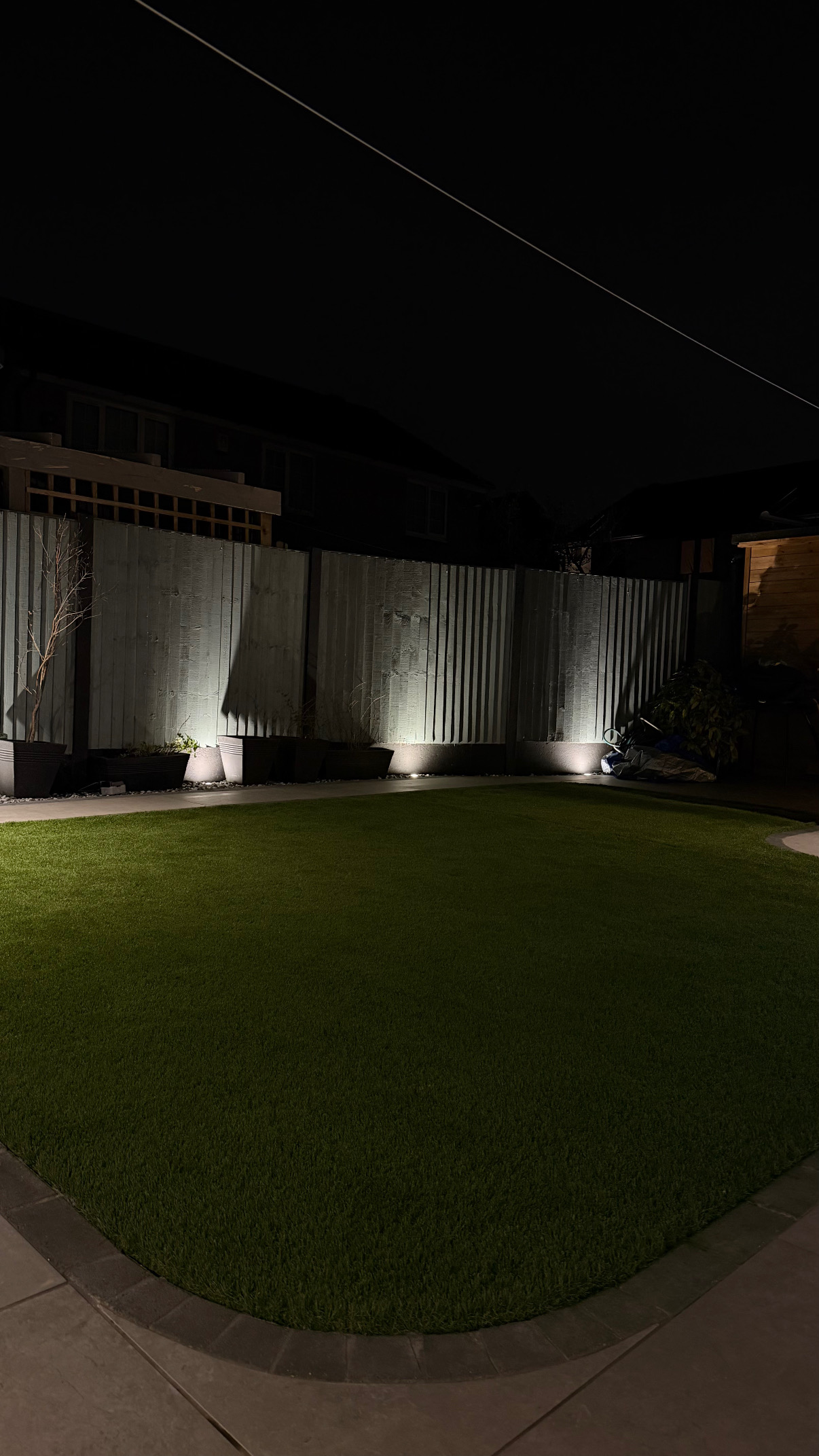 Garden fence and border uplighting at night